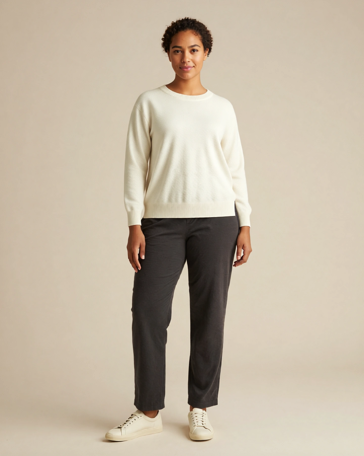 Sample A in the ivory knit look, standing in a warm studio. Concept visualization.
